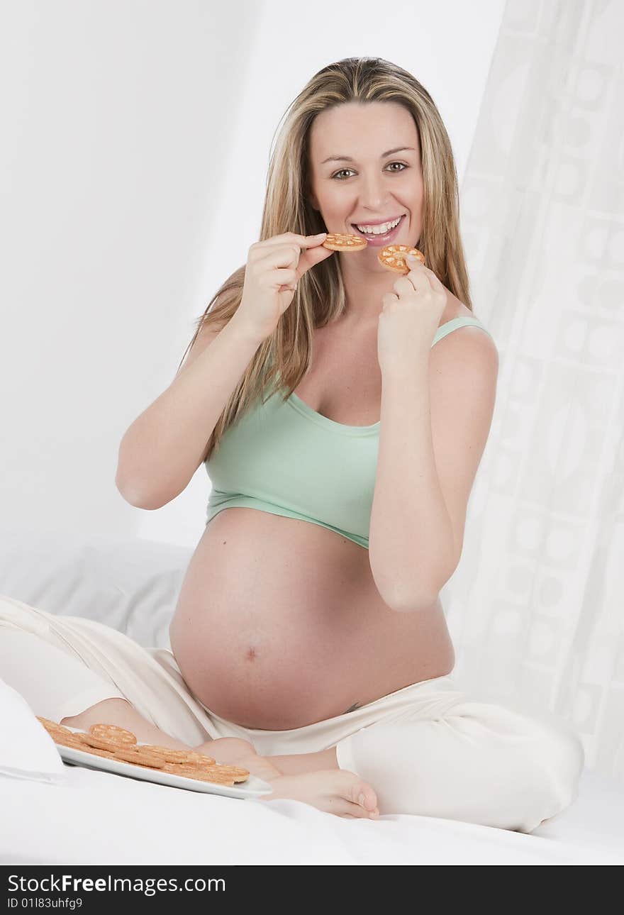 Pregnant woman in bed eating