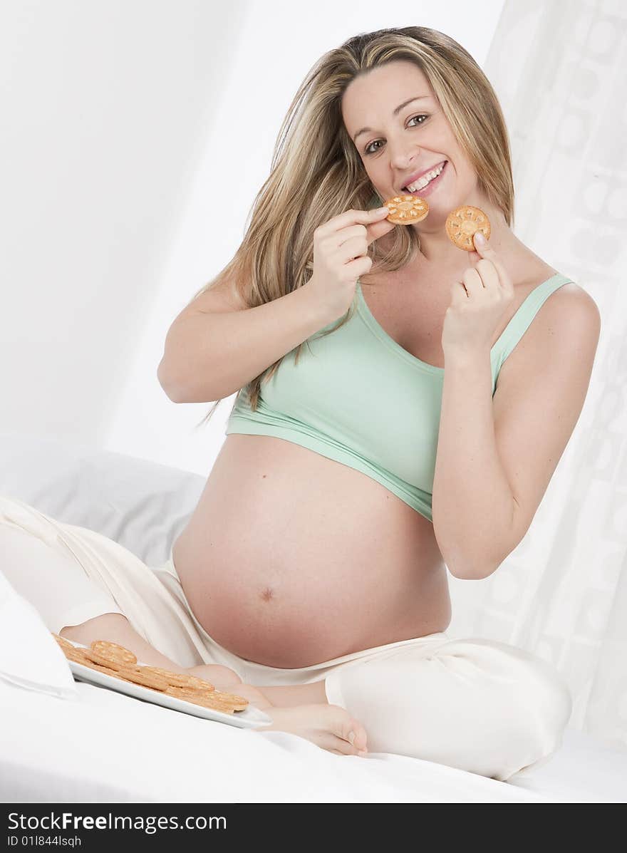 Pregnant woman in bed eating