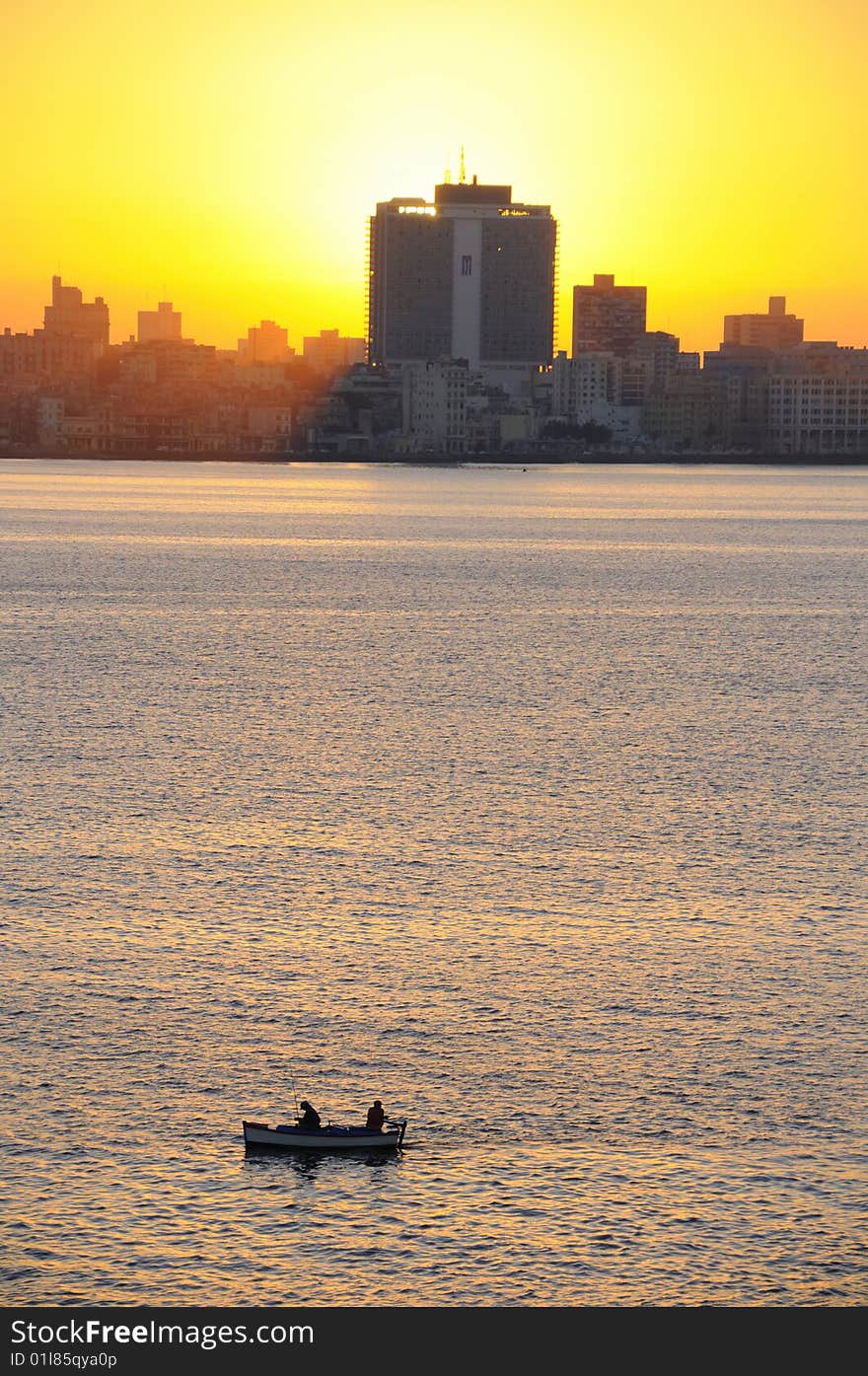 A view of havana skyline at sunset with fishing boat on the front