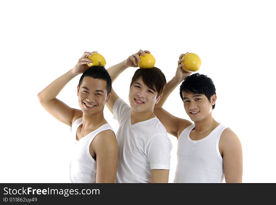 Three young man holding grapefruit on his head. Three young man holding grapefruit on his head