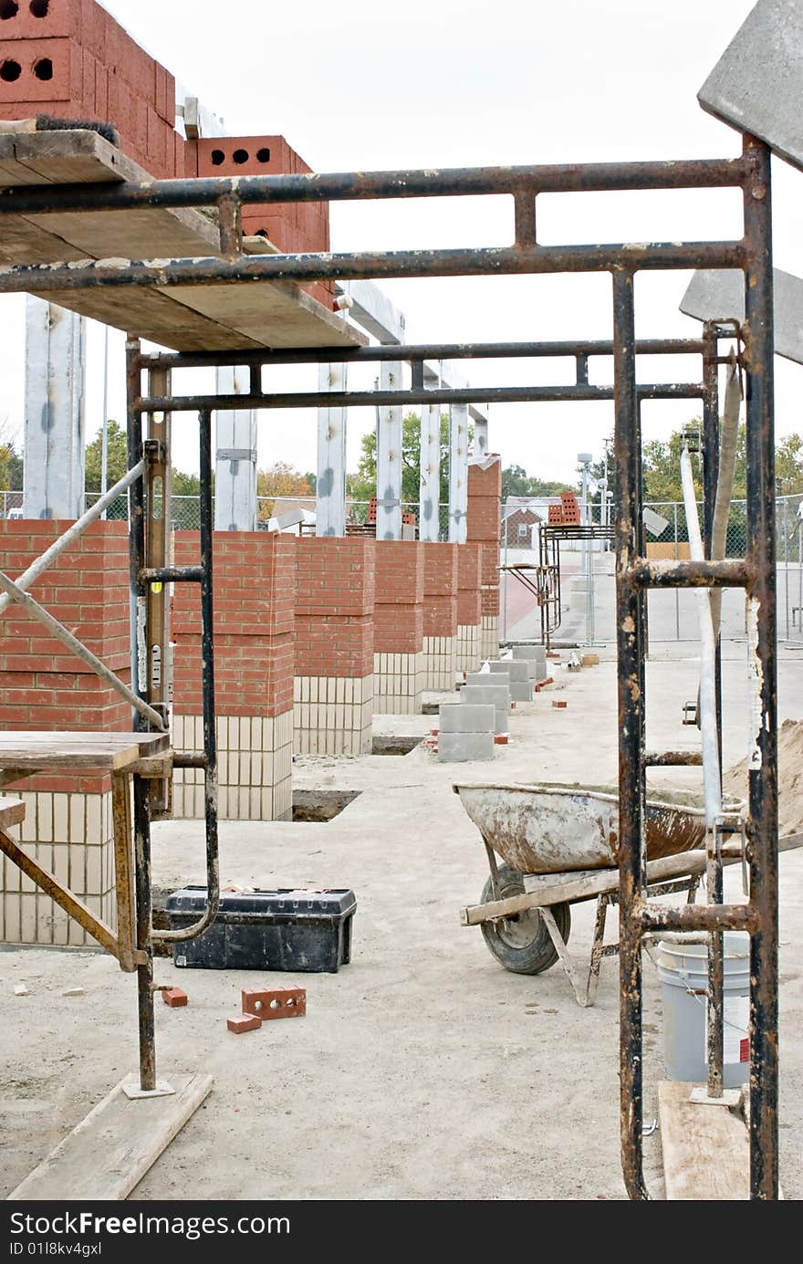 General construction site with scaffolding and brick columns.