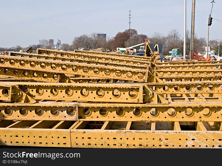 Supply of yellow steel girders piled up at construction site. Supply of yellow steel girders piled up at construction site.