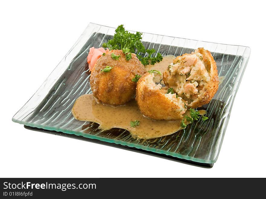 Plate of fish cakes with salmon on white