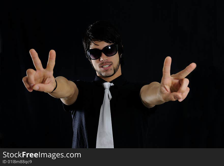 Portrait of young trendy businessman with cool gesture over black background. Portrait of young trendy businessman with cool gesture over black background