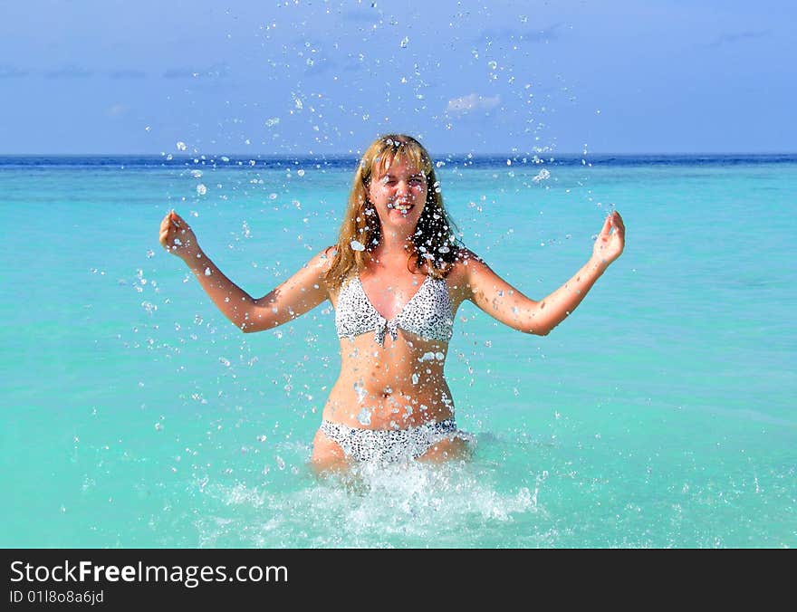 Beautiful young girl in the water over blue sky