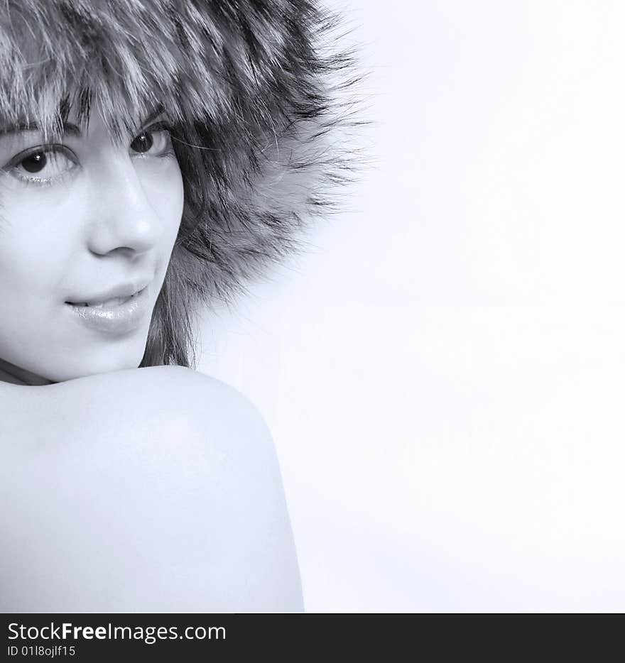 It is black - a white portrait of the beautiful girl in a fur cap close up. It is black - a white portrait of the beautiful girl in a fur cap close up.