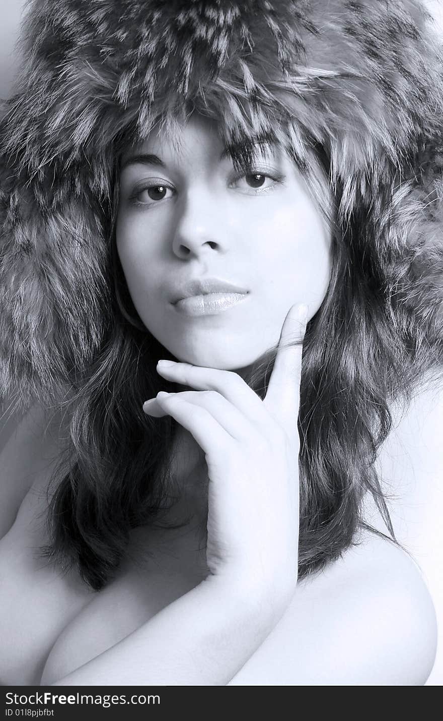 It is black - a white portrait of the beautiful girl in a fur cap close up. It is black - a white portrait of the beautiful girl in a fur cap close up.