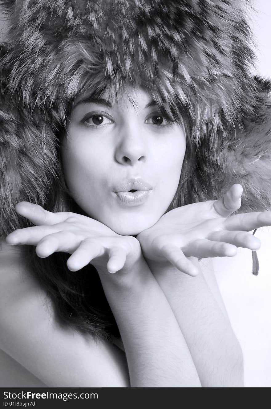 It is black - a white portrait of the beautiful girl in a fur cap close up. It is black - a white portrait of the beautiful girl in a fur cap close up.