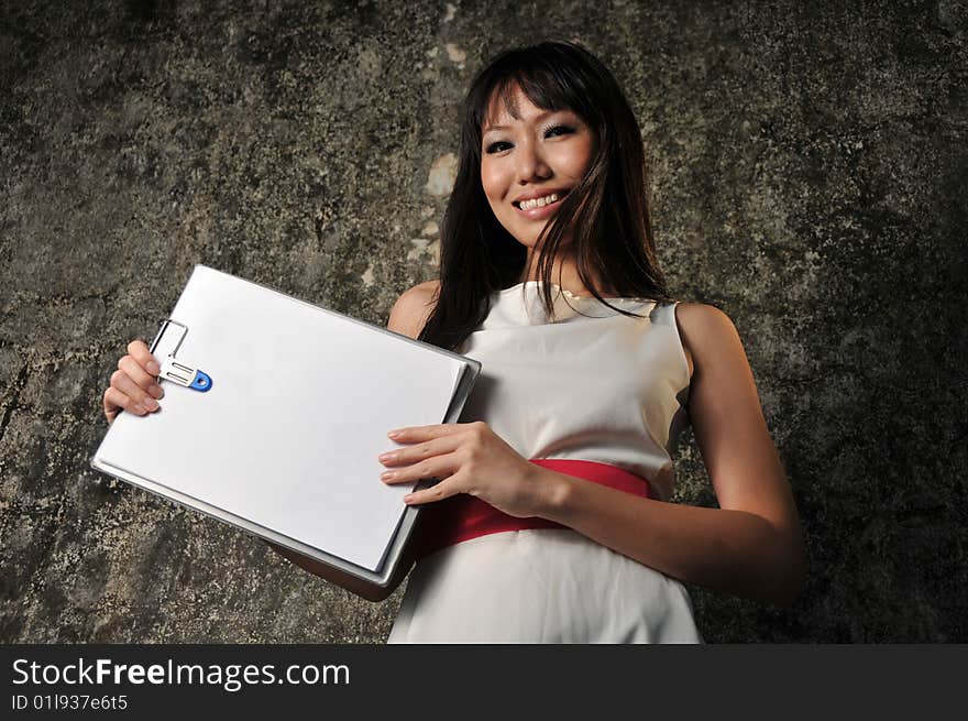 Beautiful Asian Woman Showing blank paper on clipboard. Beautiful Asian Woman Showing blank paper on clipboard.