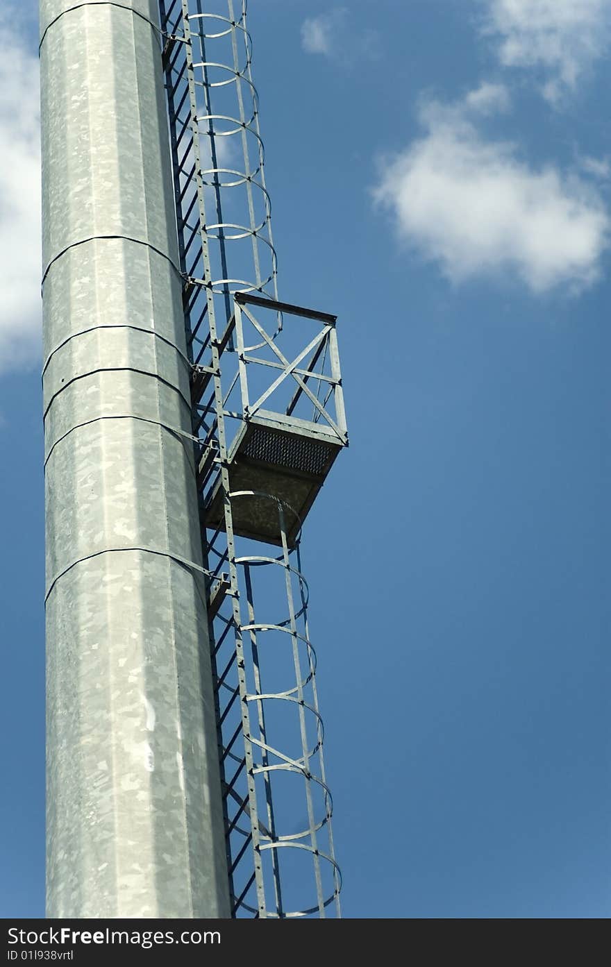 Ladder to the reflector on massive metallic pillar for the stadium lighting. Ladder to the reflector on massive metallic pillar for the stadium lighting