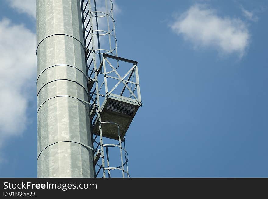 Ladder to the reflector on massive metallic pillar for the stadium lighting. Ladder to the reflector on massive metallic pillar for the stadium lighting