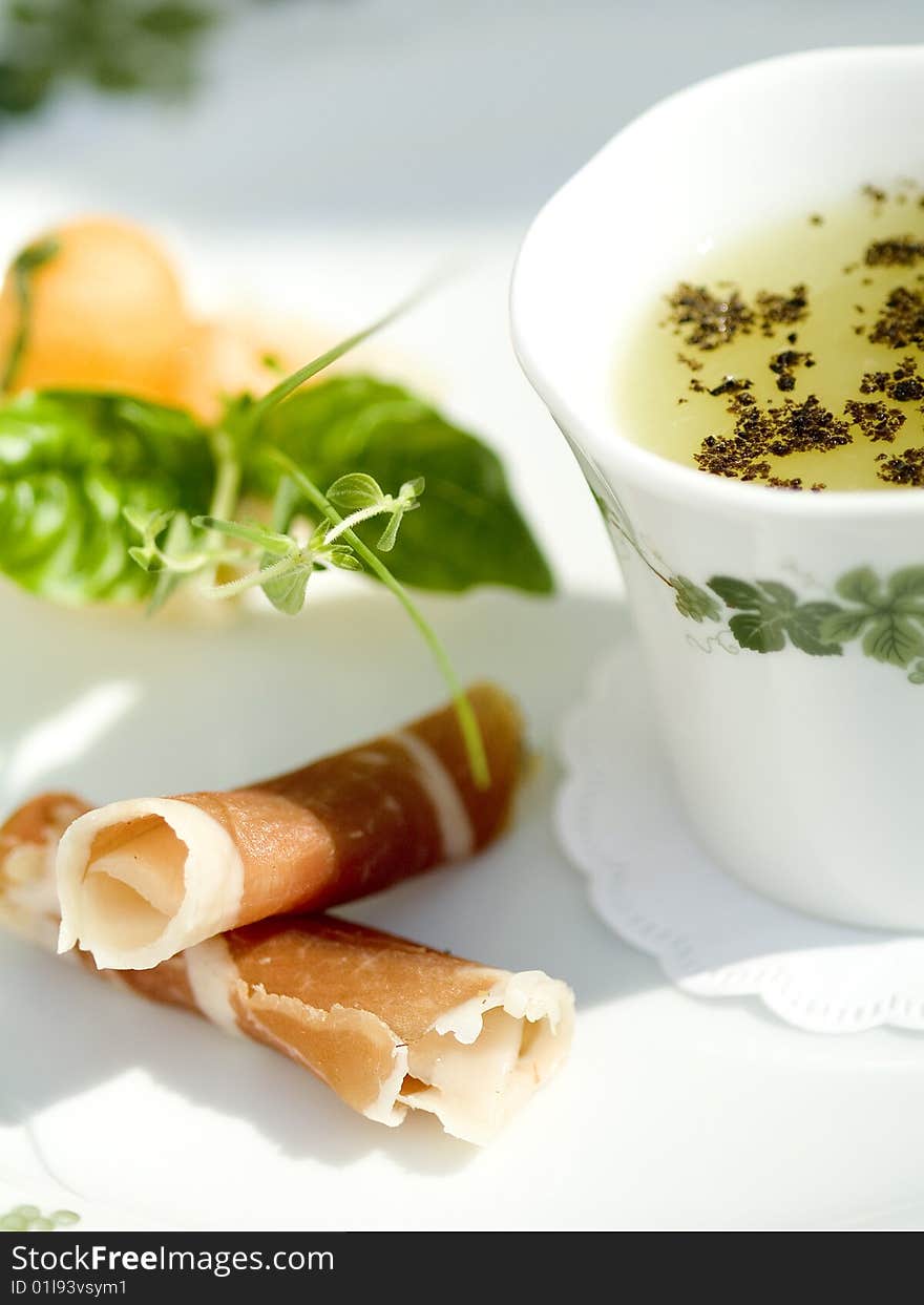 Slices of cured parma ham with melon and broth. Slices of cured parma ham with melon and broth