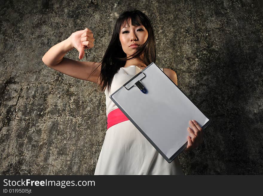 Beautiful Asian woman holding an empty clipboard and hand sign. Beautiful Asian woman holding an empty clipboard and hand sign.