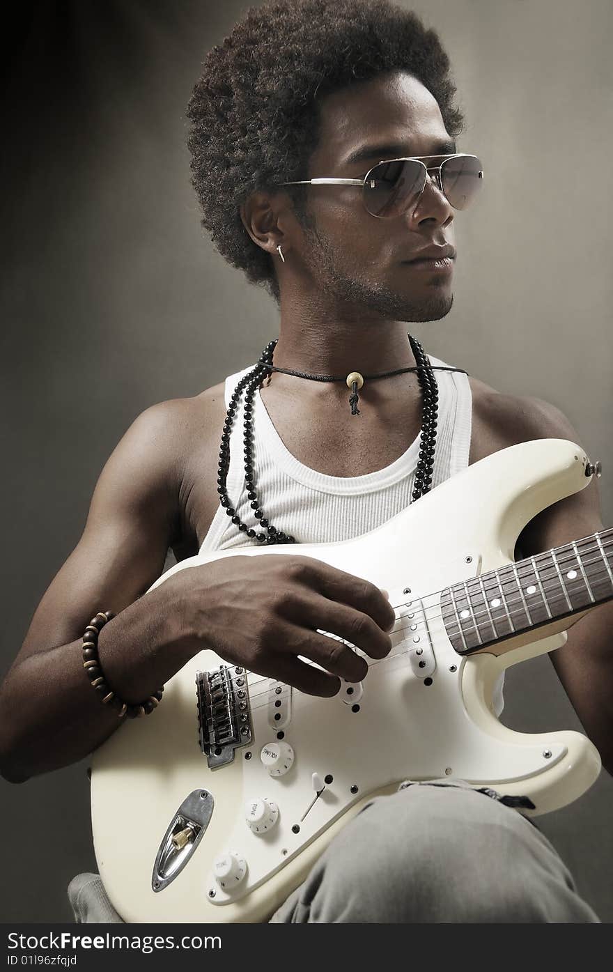 Portrait of young african man playing electric guitar