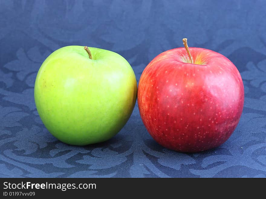 Green and red apples on blue background