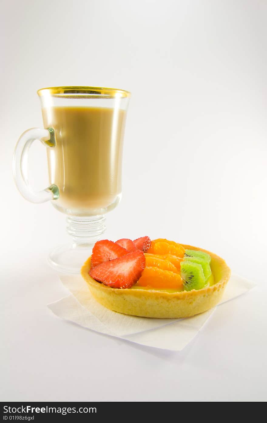 Strawberry, mandarin and kiwi custard fruit tart on a napkin with latte on a white background. Strawberry, mandarin and kiwi custard fruit tart on a napkin with latte on a white background