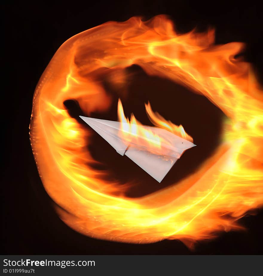 Burning paper airplane on a black background