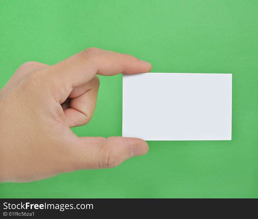 Hand holding a blank business card in the green background