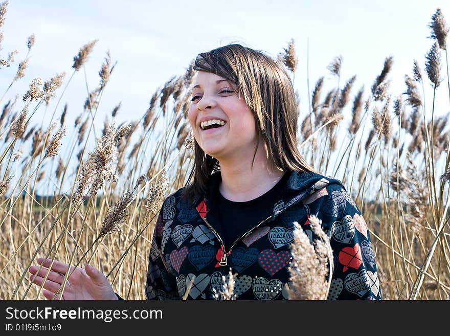 Young girl amongst pampas grass in field on a sunny day. Young girl amongst pampas grass in field on a sunny day