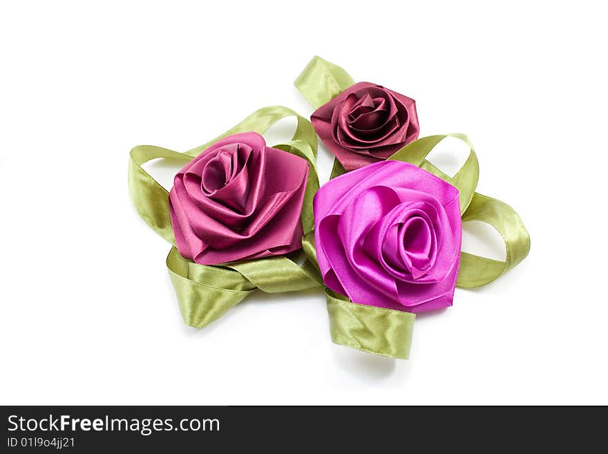 Artificial flowers-roses from satiny tapes on a white background. Artificial flowers-roses from satiny tapes on a white background