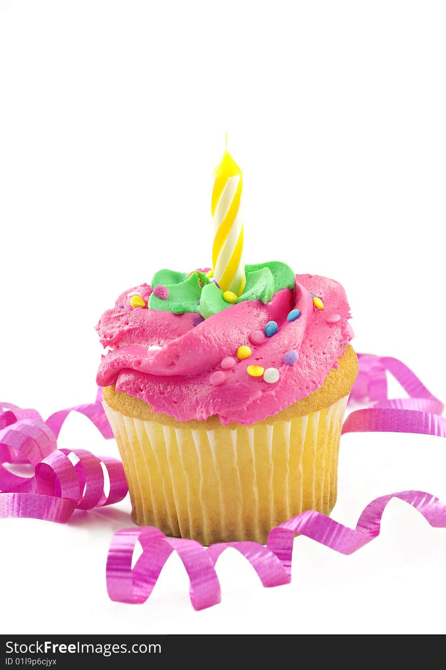 A single pink cupcake with one unlit candle decorated with curly pink ribbon, vertical with white background and copy space. A single pink cupcake with one unlit candle decorated with curly pink ribbon, vertical with white background and copy space