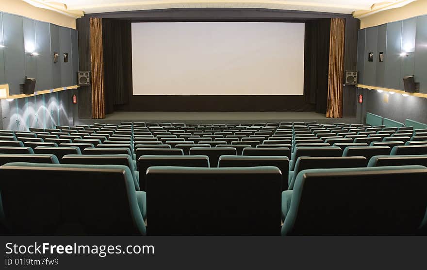 Empty cinema auditorium with line of green chairs and silver screen. Ready for adding your own picture. Empty cinema auditorium with line of green chairs and silver screen. Ready for adding your own picture.