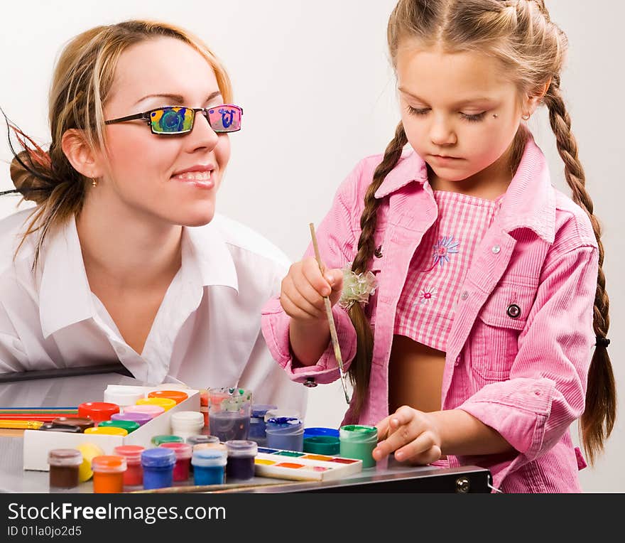 Little girl playing with mom, painting her fingers. Little girl playing with mom, painting her fingers