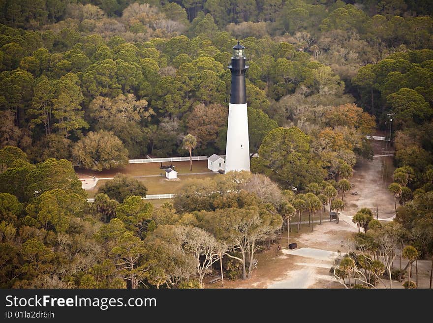Hunting island lighthouse, built in 1859, on Hunting Island South Carolina, aerial view. The lighthouse is surrounded by maritime pine, live oak, and palmetto forest. Hunting island lighthouse, built in 1859, on Hunting Island South Carolina, aerial view. The lighthouse is surrounded by maritime pine, live oak, and palmetto forest.