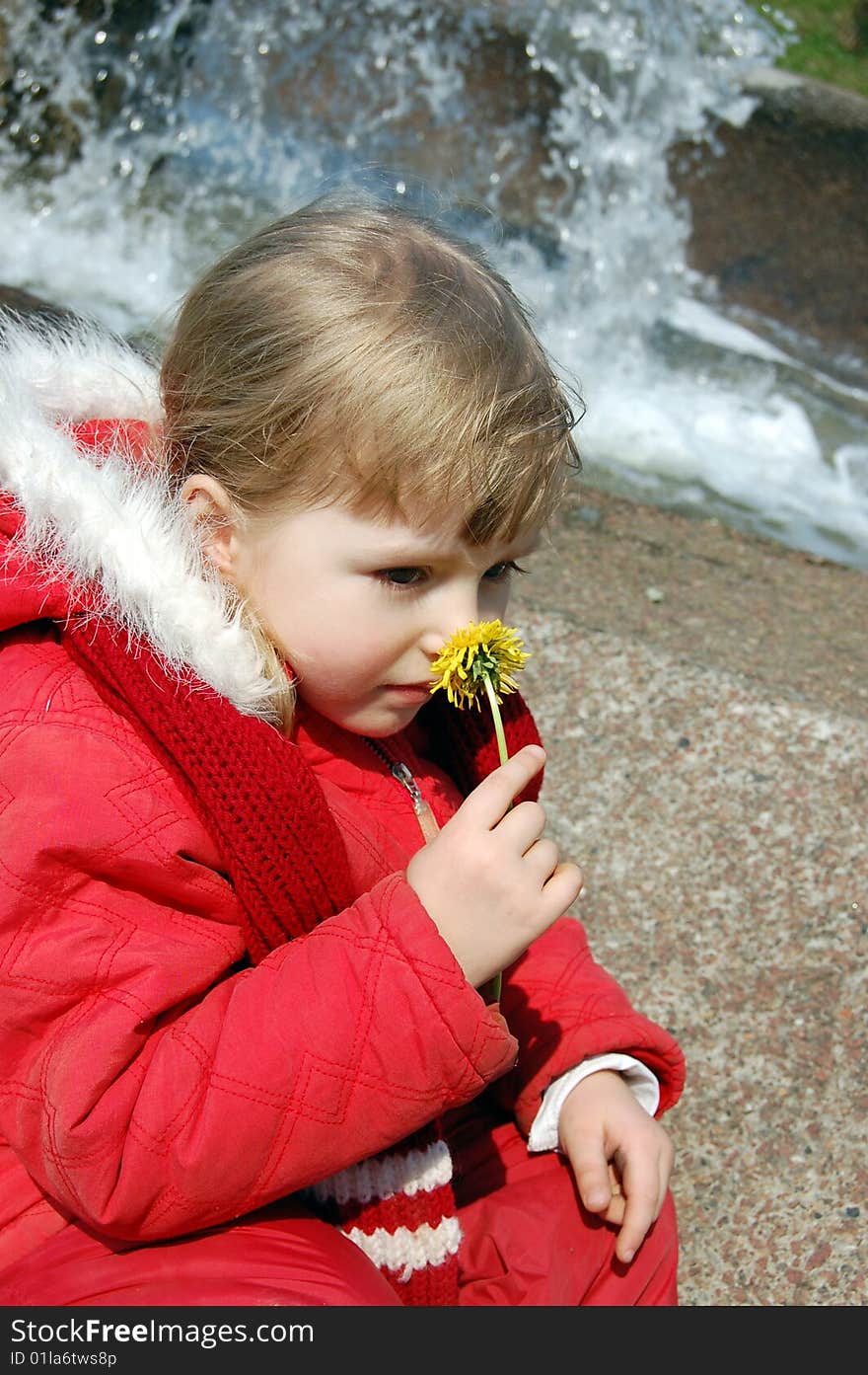 Little girl smelling a flower spring