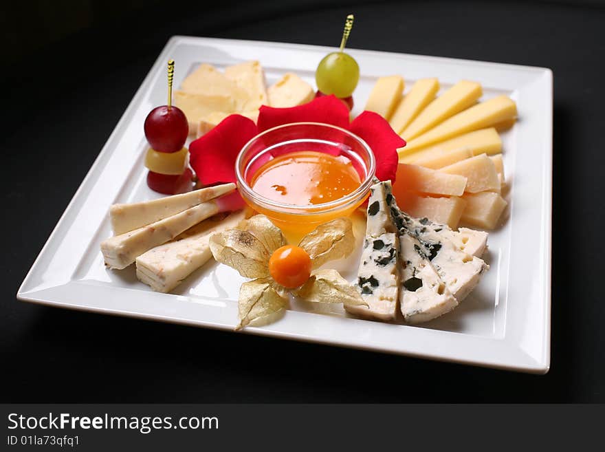 Fruit and cheeses are in ceramic tableware.