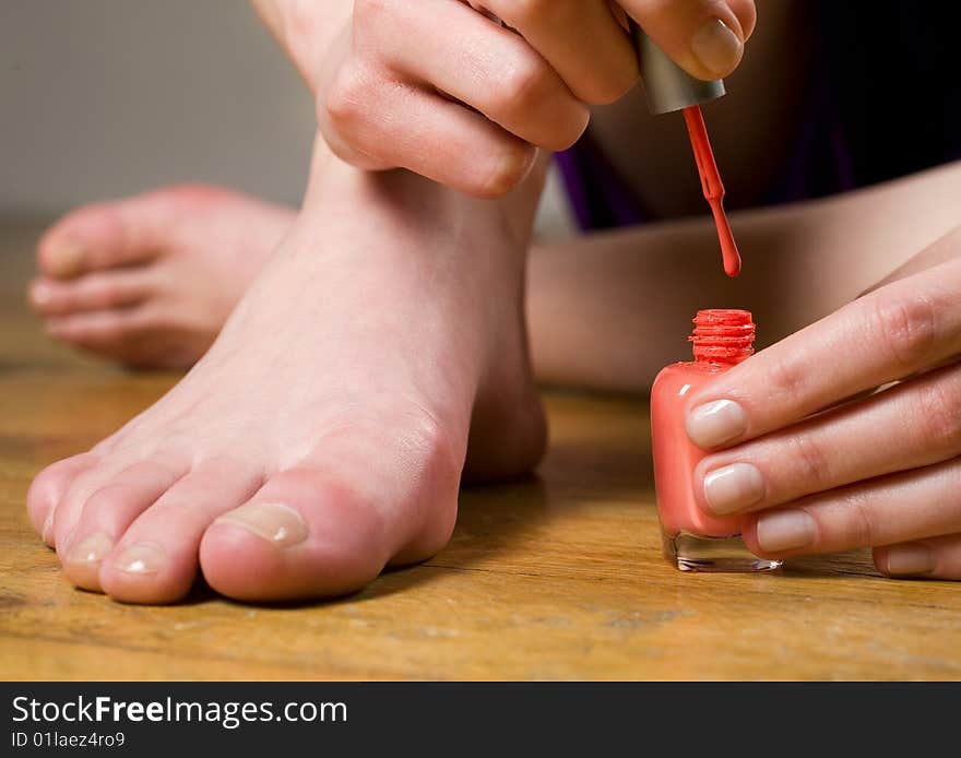 Woman applying nail polish on toe nails. Woman applying nail polish on toe nails