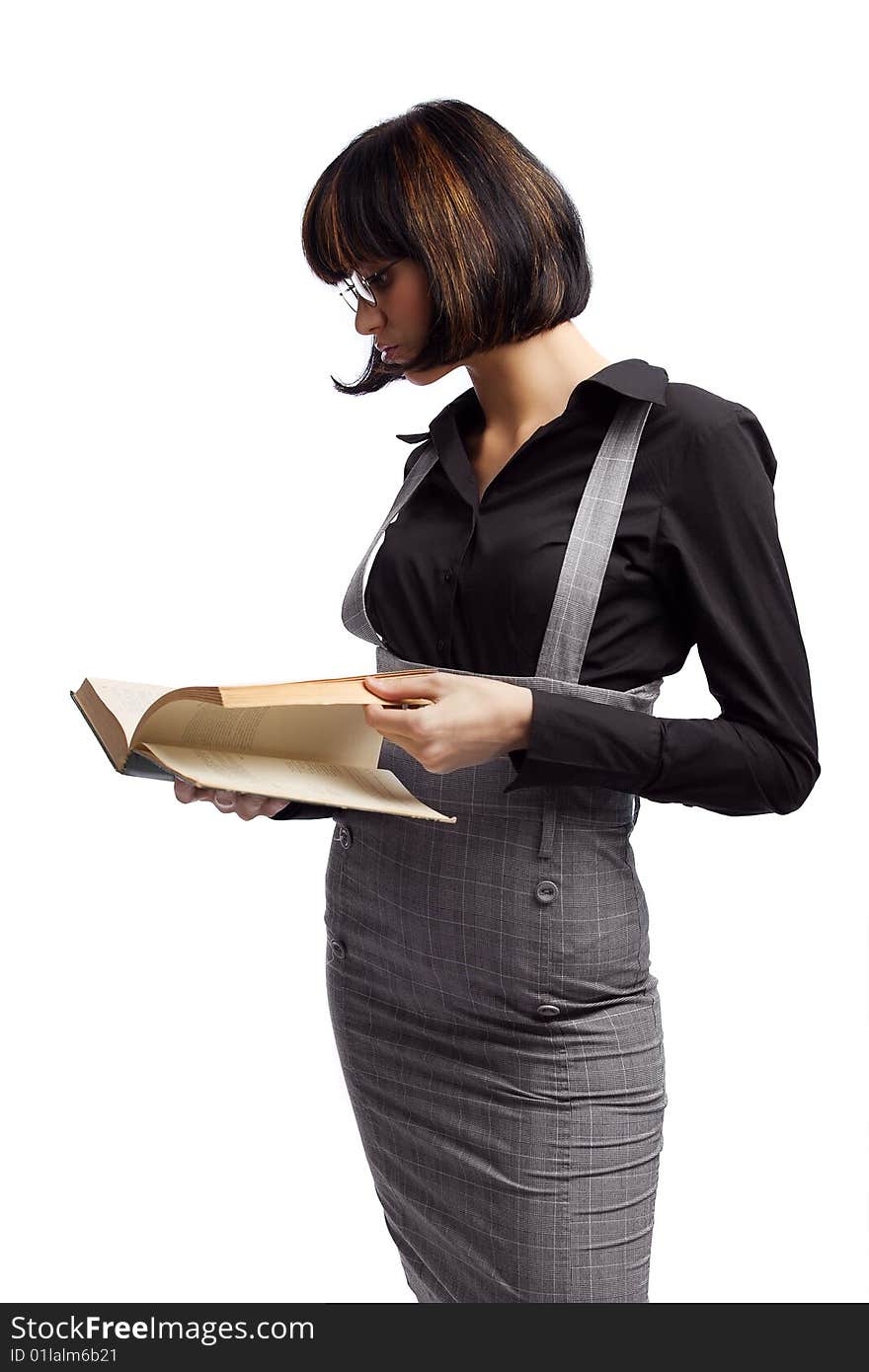 Clever brunette schoolgirl looking in the book over white background