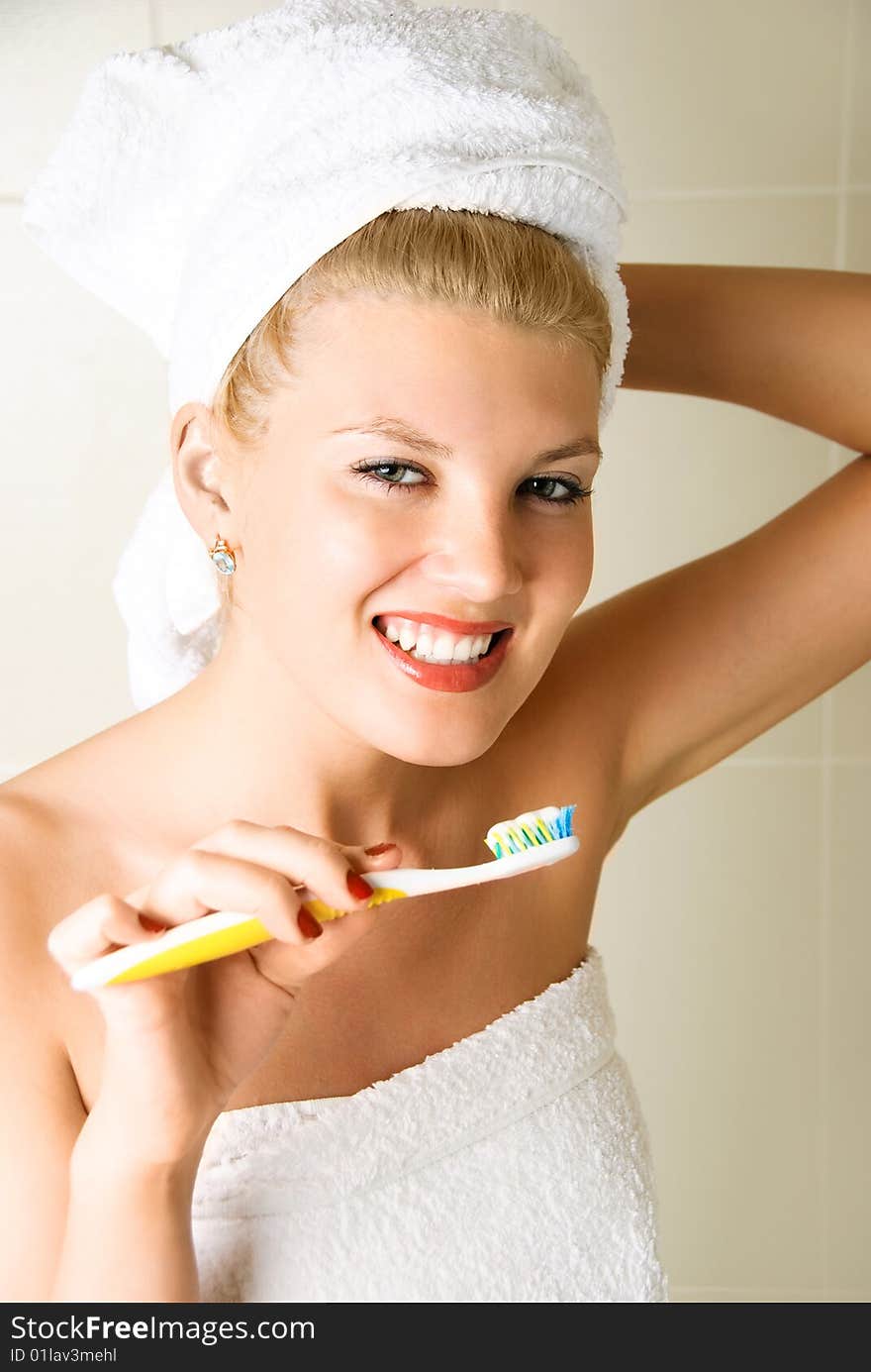 Happy young beautiful woman brushing her teeth in the bathroom. Happy young beautiful woman brushing her teeth in the bathroom