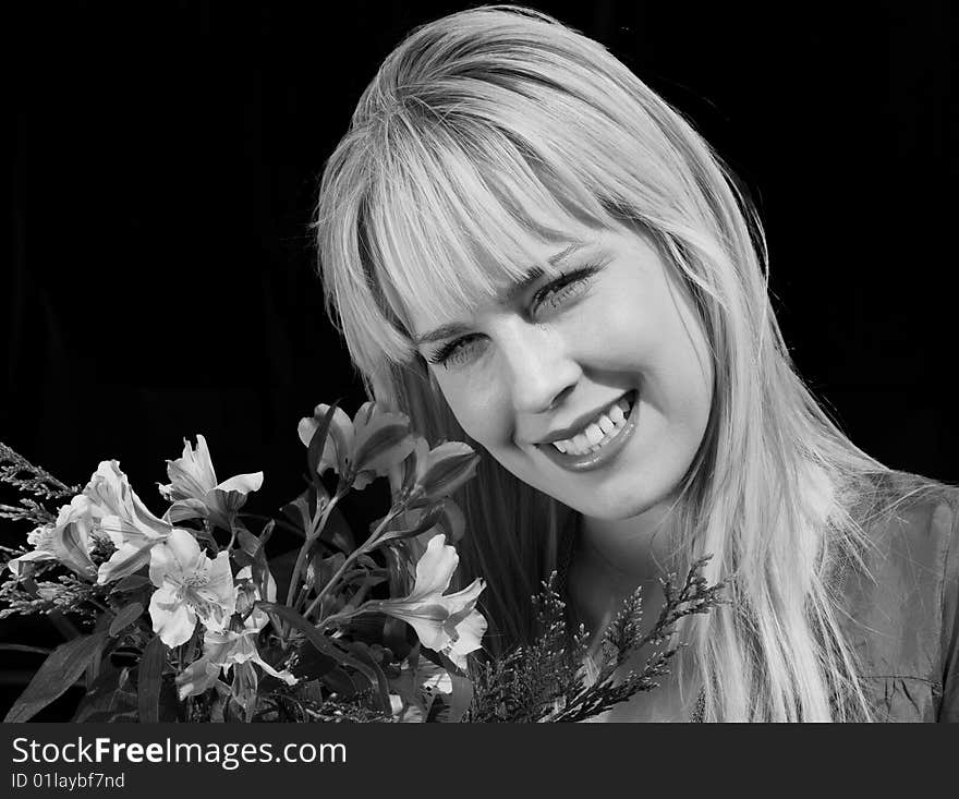 Black & White portrait of a beautiful blond girl holding a bouquet of flowers and smiling. Black & White portrait of a beautiful blond girl holding a bouquet of flowers and smiling