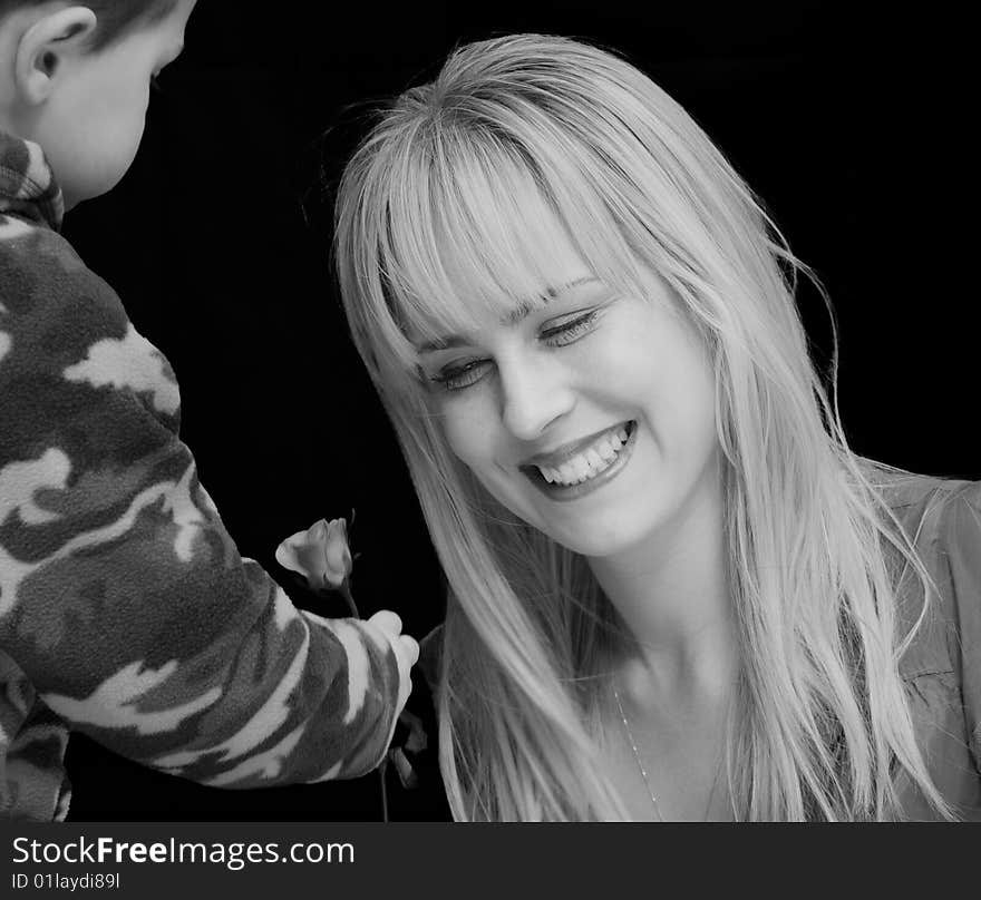 Little boy handing flower to a beautiful woman