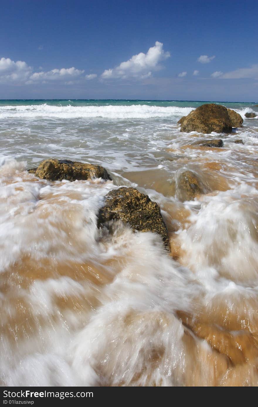 A wave breaking on a beach on a tropical island. A wave breaking on a beach on a tropical island.