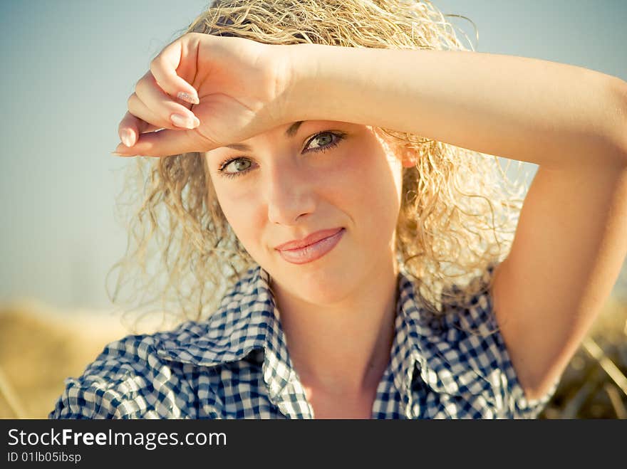 Close-up portrait of a beautiful country girl sitting on the haystack