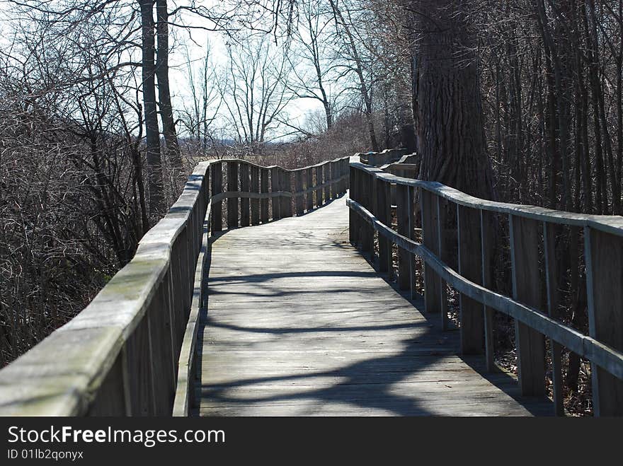 Empty wooden boardwalk . Beautiful sunny early spring day.