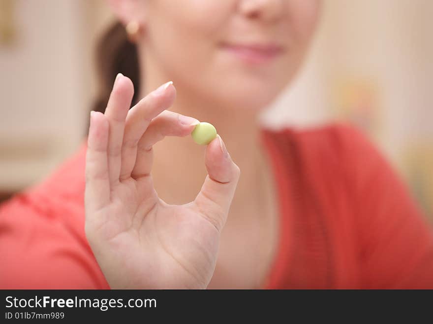 A photo of young girl with green vitamin. A photo of young girl with green vitamin