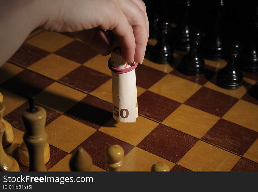 Chess on chessboard with banknote participating in a game. Chess on chessboard with banknote participating in a game