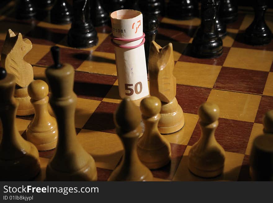 Chess on chessboard with banknote participating in a game. Chess on chessboard with banknote participating in a game