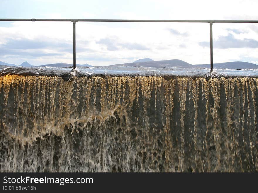 A reservoir flooding with peat stained water mountains in the background. A reservoir flooding with peat stained water mountains in the background.