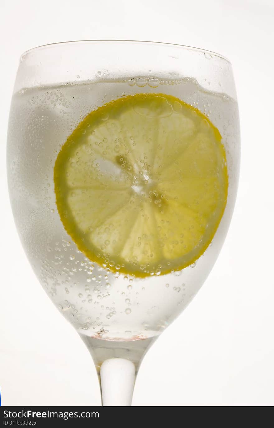 a glass of ice cold lemon drink with ice cubes. a glass of ice cold lemon drink with ice cubes