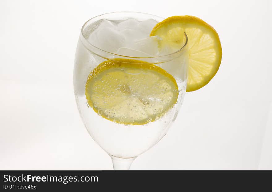 A glass of ice cold lemon drink with ice cubes. A glass of ice cold lemon drink with ice cubes