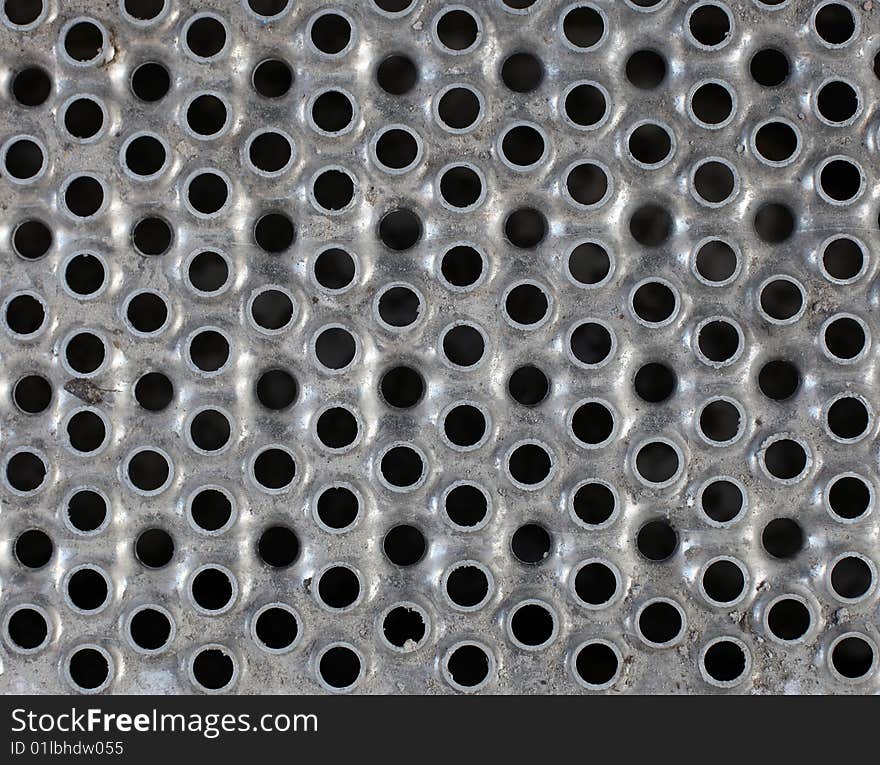 Metal plate background with holes for multiple uses