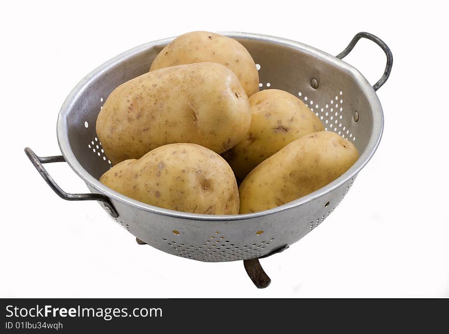 Potatoes in a metal colander on white