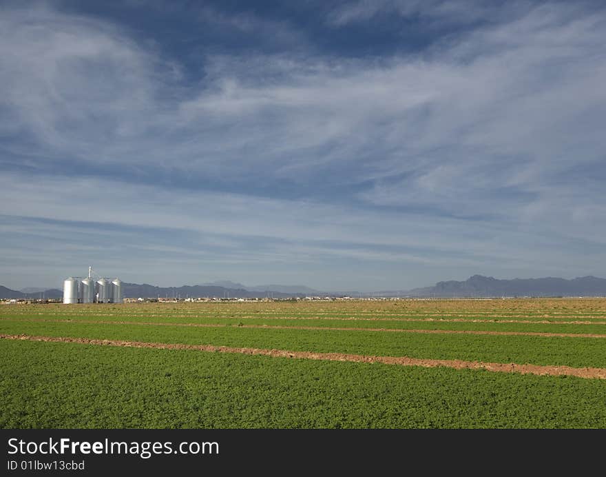 Beautiful farm land with majestic cloudscape and silo and mountains in background with copyspace. Beautiful farm land with majestic cloudscape and silo and mountains in background with copyspace