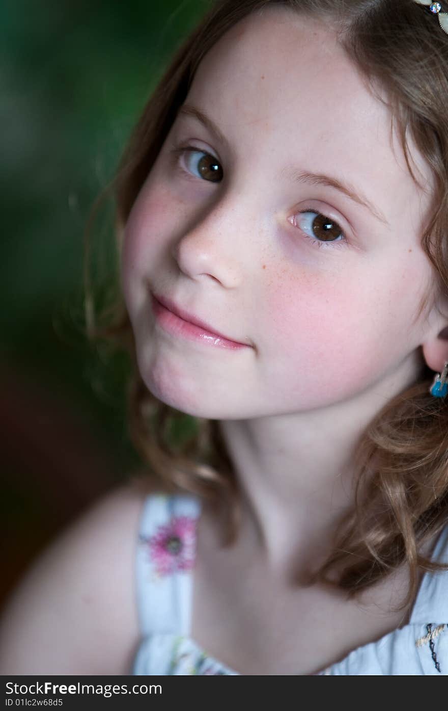 A pretty young blonde girl with a pensive expression and wearing a flowered sun dress. A pretty young blonde girl with a pensive expression and wearing a flowered sun dress