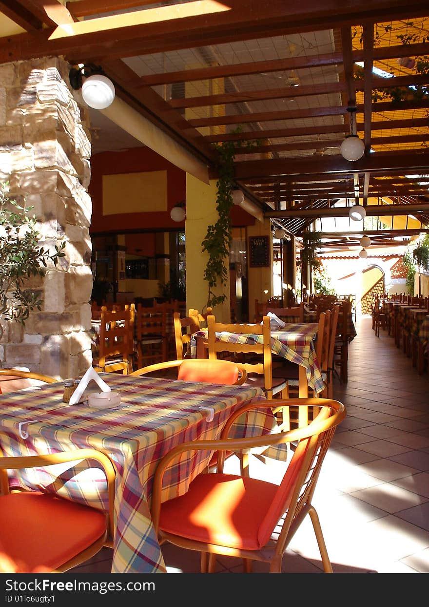 Cover terrace of greek taverna with chairs and tables