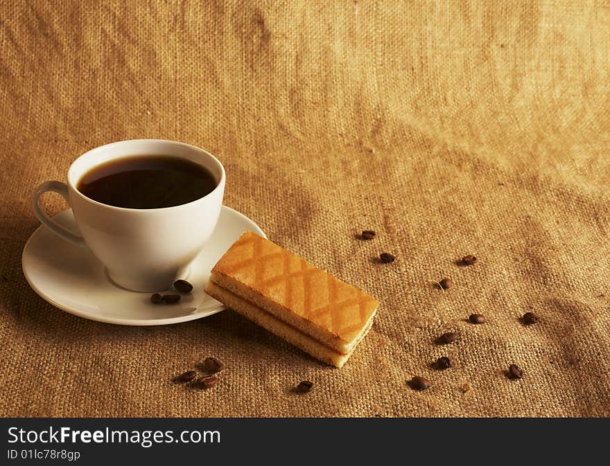 Cup of coffee and cake at the textile background. Cup of coffee and cake at the textile background